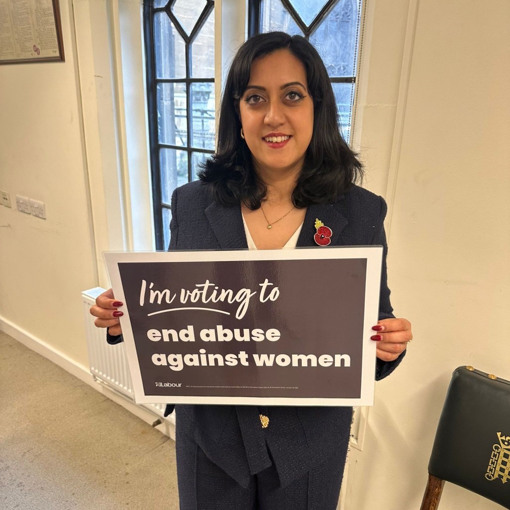 Kirith Entwistle holding a banner which states: I'm voting to end abuse against women